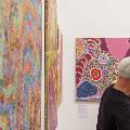 Father and son looking at Aboriginal paintings on an exhibition wall.