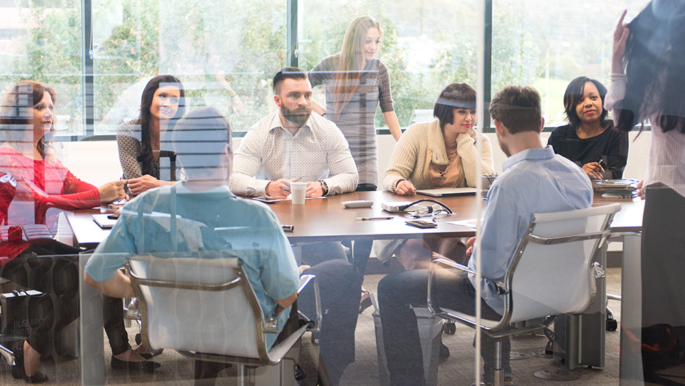 A stock image of a group of people meeting in a boardroom