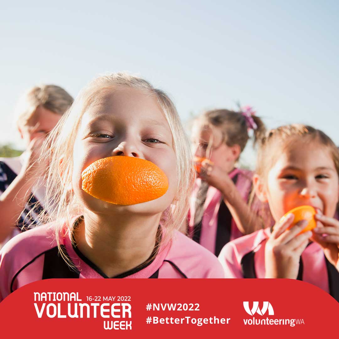 Young footballers smiling with a cut orange in their mouth